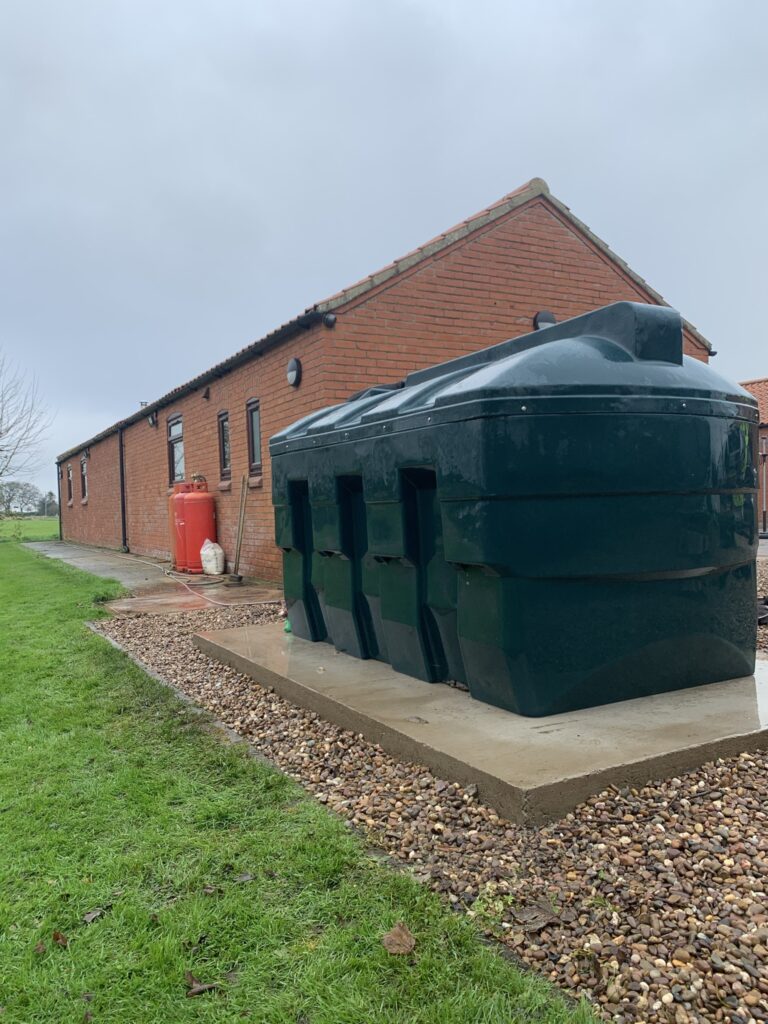 Bunded oil tank next to a brick building